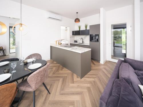 a kitchen and living room with a table and a couch at Harderwold Villa - 551 in Zeewolde