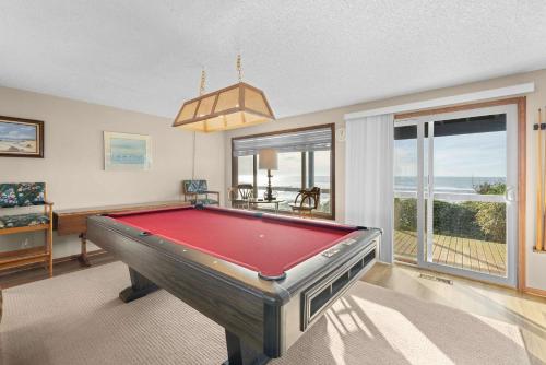 a pool table in a living room with a view of the ocean at Boone Family Retreat in Lincoln Beach