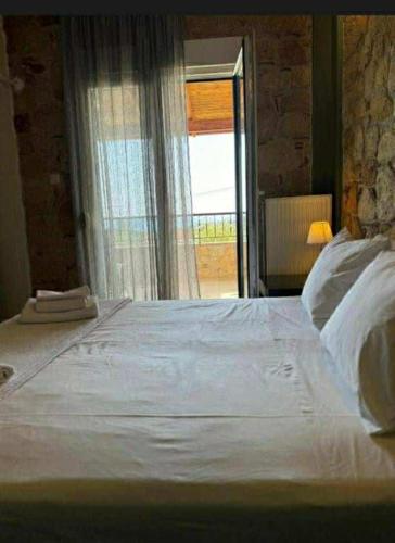 a bedroom with a large white bed with a window at Villa Paliouri in Paliouri