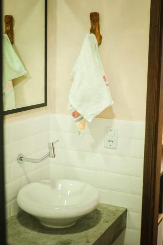 a bathroom with a white sink and a towel at Hospedaria Lunar in Palmeiras