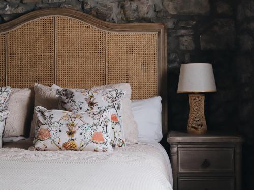 a bed with pillows and a lamp on a night stand at La Casina de Isoba in Isoba