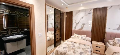 a bedroom with a bed and a sink and a mirror at Sharm Hills Azure Paradise in Sharm El Sheikh