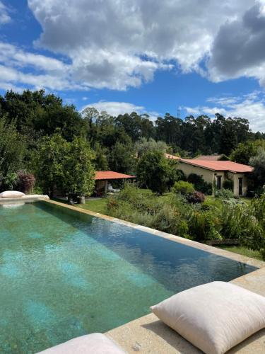a swimming pool in front of a house at Casa de Vilar de Rei, a tranquilidade do mundo rural in Ponte de Lima