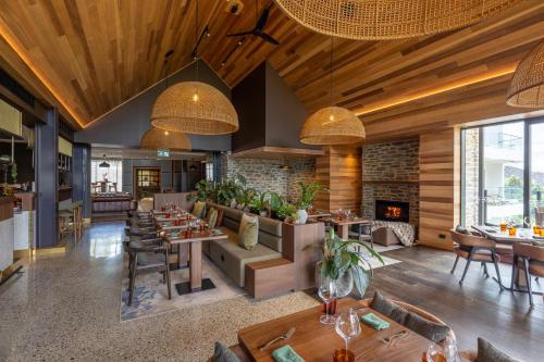 a restaurant with tables and chairs and a fireplace at Coronet Ridge Resort in Queenstown