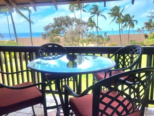 a table and chairs on a balcony with a view of the ocean at Molokai Kepuhi Beach Gem in Kepuhi