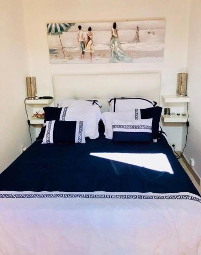 a bedroom with a blue and white bed with a picture at Maisonnette Les Coraux residence prive avec piscine in Canet-en-Roussillon