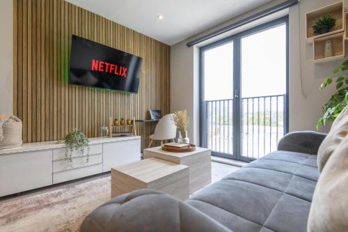 a living room with a couch and a tv on a wall at Premium Centre Retreat - Work & Relax - Pool Table in Leeds