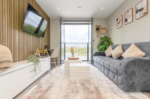 a living room with a gray couch and a window at Premium Centre Retreat - Work & Relax - Pool Table in Leeds