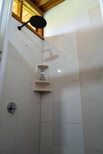 a shower with a white tiled wall at Coati Lodge Misahualli in Tena