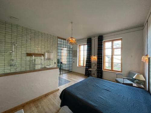 a bedroom with a blue bed and a bathroom at Hydra - Gutshaus Bückling in Rambin