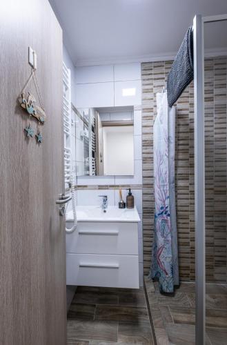 a bathroom with a sink and a mirror at Mirabella apartman in Csopak