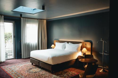 a hotel room with a bed and a window at Aethos Hotel Milan in Milan