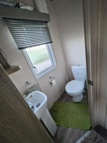 a small bathroom with a toilet and a sink at Hills residence in Morecambe