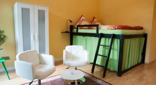 a bedroom with a bunk bed with two chairs and a table at Apartment Alaune in Dresden