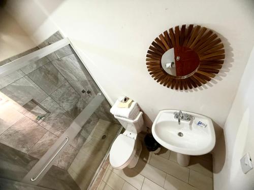 a bathroom with a toilet and a sink and a mirror at Hotel Nuevo Amanecer in Real de Catorce