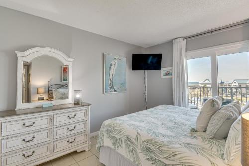a bedroom with a bed and a dresser with a mirror at Gulf Highlands Getaway with 6 Pools and Beach Access in Gulf Shores