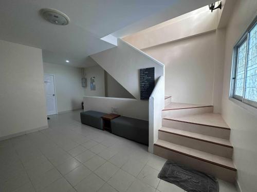 a room with a staircase with a couch and a stair case at M&M Kata Beach in Kata Beach