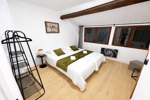 a white bedroom with a bed and a ladder at Maison Connectée Serenia in Méru