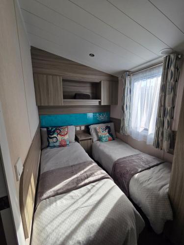 two beds in a small room with a window at Poole Rockley Park Dorset in Poole
