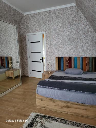 a bedroom with a bed and a large mirror at Shabran Pearl A-Frame in Surra