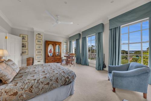 a bedroom with a bed and a table and chairs at Castle by the Sea - Tilba Road 26 in Bermagui