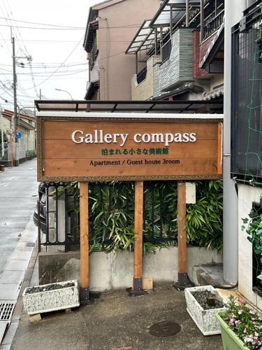 a sign for a calley compass on the side of a building at Gallery Compass- Art Stay with Breakfast Free Parking in Osaka