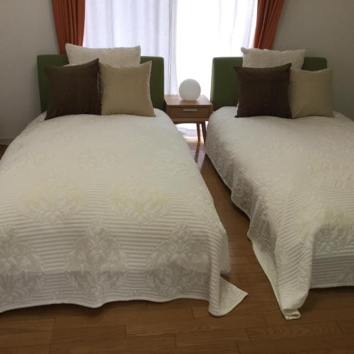 two beds sitting next to each other in a bedroom at La Curación in Naoshima
