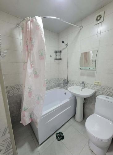a bathroom with a tub and a toilet and a sink at Elan apartment in Gori