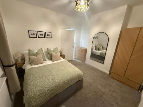 a bedroom with a bed and a large mirror at Sleek 1 Bed Flat near Warwick Castle with Parking in Warwick