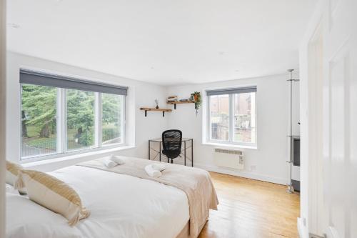 a white bedroom with two beds and two windows at Central Apt-2Bed 2Bath-AC unit-By FabAccommodation in Bristol