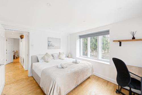 a white bedroom with a bed and a window at Central Apt-2Bed 2Bath-AC unit-By FabAccommodation in Bristol