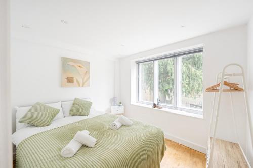 a white bedroom with a bed with towels on it at Central Apt-2Bed 2Bath-AC unit-By FabAccommodation in Bristol