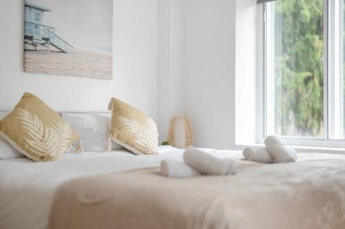 a white bed with white pillows and a window at Central Apt-2Bed 2Bath-AC unit-By FabAccommodation in Bristol