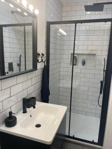 a white bathroom with a sink and a shower at Cosy nap under the Paps in Killarney