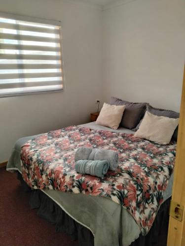 a bed with two pillows on it in a bedroom at Cabañas Haru Puerto Natales in Puerto Natales