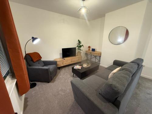 a living room with a couch and a tv at Sleek 1 Bed Flat near Warwick Castle with Parking in Warwick