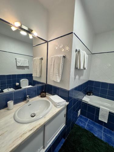 a blue and white bathroom with a sink and a tub at Casa Gatu Verdi-Garden Apartment with Pool in Carvoeiro