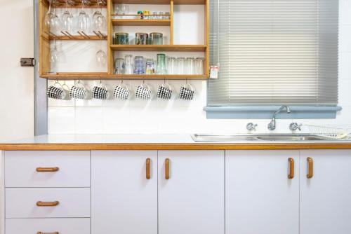 a kitchen with white cabinets and a sink and a window at Koala Lodge Cottage 5 in Iluka
