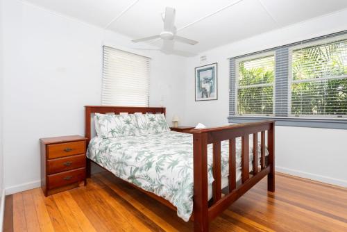 a bedroom with a bed and a ceiling fan at Koala Lodge Cottage 5 in Iluka