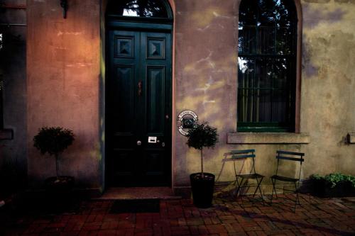 una puerta negra de una casa con dos sillas en Provenance Accommodation, en Beechworth