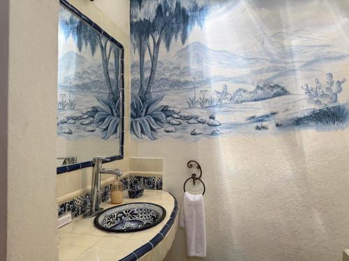 a bathroom with a sink and a painting on the wall at Hotel Centenario Bernal in Bernal