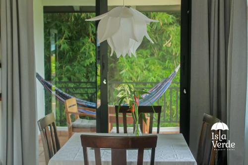 a dining room table with chairs and a hammock at Hotel Isla Verde in Boquete