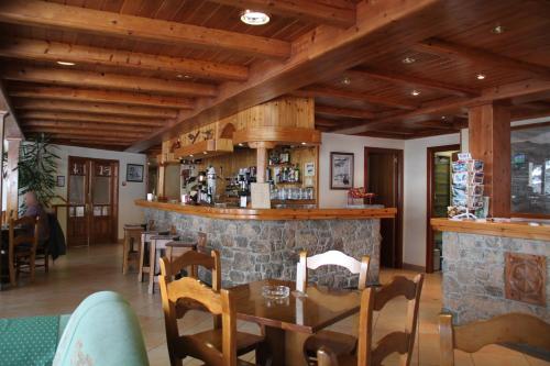 a restaurant with wooden ceilings and a stone bar at Hotel Soldeu Maistre in Soldeu