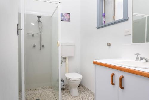 a bathroom with a shower and a toilet and a sink at Koala Lodge Studio 2 in Iluka