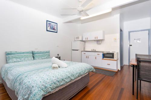 a small bedroom with a bed and a kitchen at Koala Lodge Studio 2 in Iluka