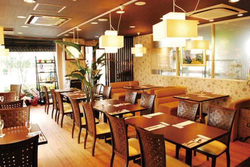 a restaurant with wooden tables and chairs in a room at Comfesta Inn Kabe in Ome