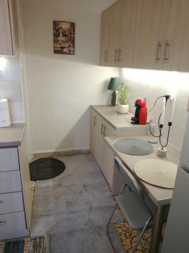 a small kitchen with white cabinets and a table at 150 metres from the beach dafnes Patra in Patra