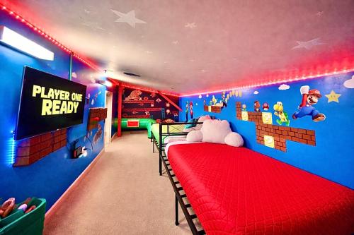 a bedroom with a red bed in a room with mickey mouse wallpaper at Mario Room Waterfront Downtown View Cedar Point! in Sandusky