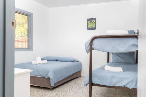 a bedroom with two bunk beds and a window at Koala Lodge Unit 3 in Iluka