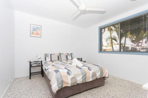 a bedroom with a bed with a ceiling fan at Koala Lodge Unit 3 in Iluka